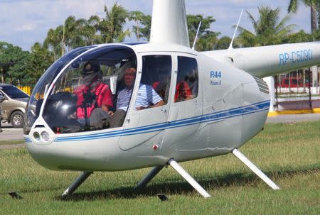 File photo - Then-local mayor of Davao city Rodrigo Duterte (R), aboard a helicopter, arrives at the provincial capitol in Tagum city, Davao del Norte, southern Philippines for the Regional Peace and Order Council meeting, April 20, 2015. REUTERS/Lean Daval Jr.