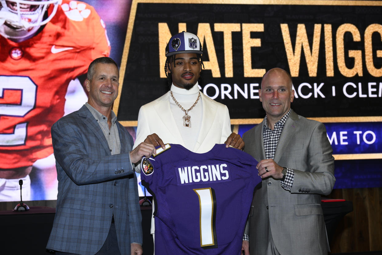 Baltimore Ravens first-round draft pick Nate Wiggins, center, poses with head coach John Harbuagh, left, and executive vice president and general manager Eric DeCosta, right, at an NFL football news conference, Friday, April 26, 2024, in Owings Mills, Md. (AP Photo/Nick Wass)