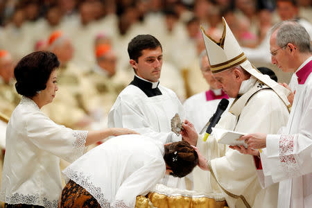 Pope Francis baptizes a faithful during the Easter vigil Mass in Saint Peter's Basilica at the Vatican, April 20, 2019. REUTERS/Remo Casilli