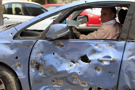 A man moves his damaged car away from the site of a car bomb attack on the convoy of Egyptian public prosecutor Hisham Barakat near his house at Heliopolis district in Cairo, Egypt, June 29, 2015. REUTERS/Mohamed Abd El Ghany