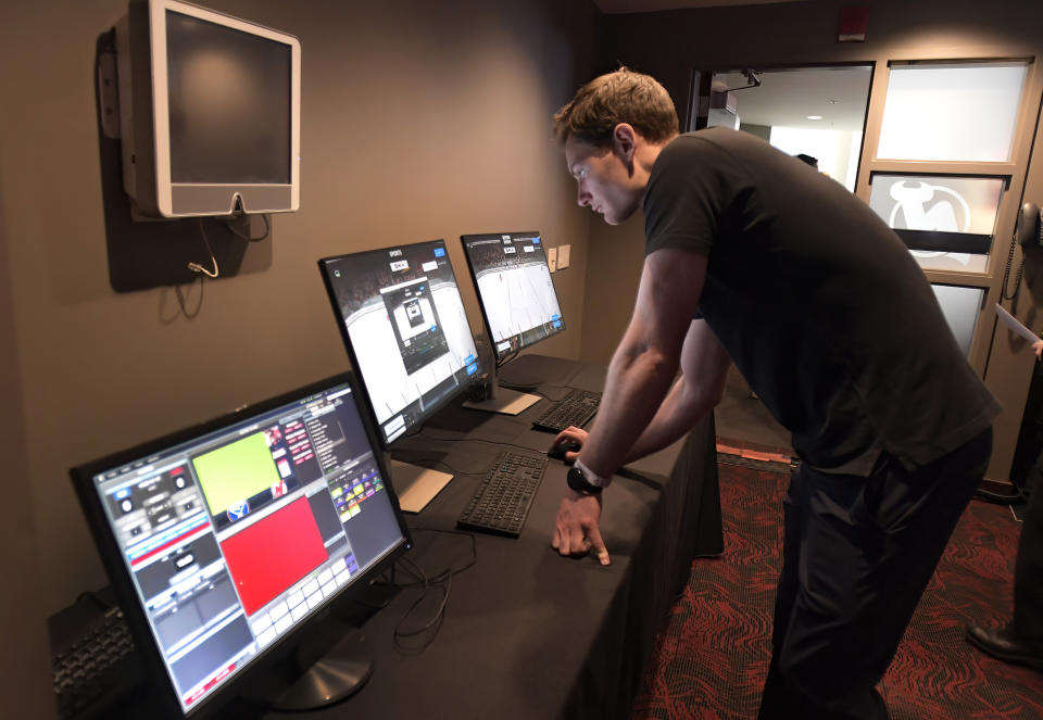 A technician sets up the latest advances in puck and player tracking at a tech showcase before an NHL hockey game between the Buffalo Sabres and New Jersey Devils, Thursday, April 21, 2022, in Newark, N.J. Some data from the NHL’s puck and player tracking system is expected to be publicly available during the upcoming playoffs, and that’s just the start of some of the technological twists that are coming to hockey arenas and broadcasts sooner than later. Custom camera angles and replays for fans at their seats and virtual and augmented reality are among the advancements the league is working on. (AP Photo/Bill Kostroun)