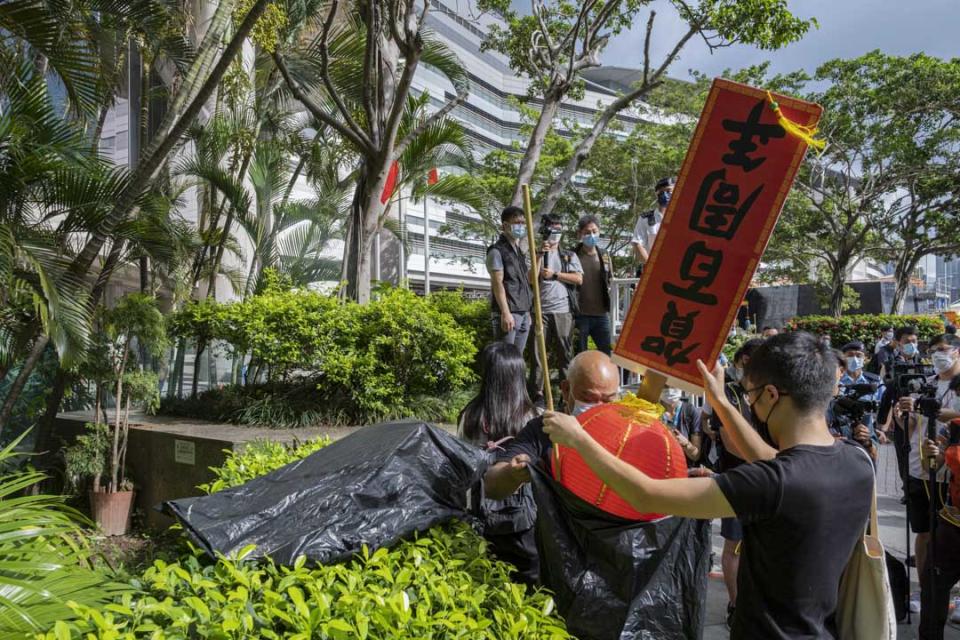 2021年7月1日香港灣仔，社民連的成員拿著寫上「賀百周年」紅燈籠到會議展覽中心外抗議。