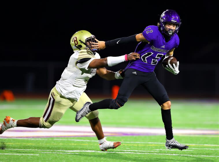 Norwalk quarterback Rylee Sosa tries to evade a Bellflower defender during the first half Friday night.