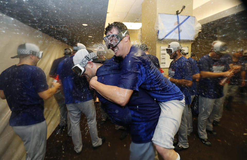 The Los Angeles Dodgers celebrate clinching a playoff spot after beating the San Francisco Giants in a baseball game in San Francisco, Saturday, Sept. 29, 2018. (AP Photo/Jim Gensheimer)