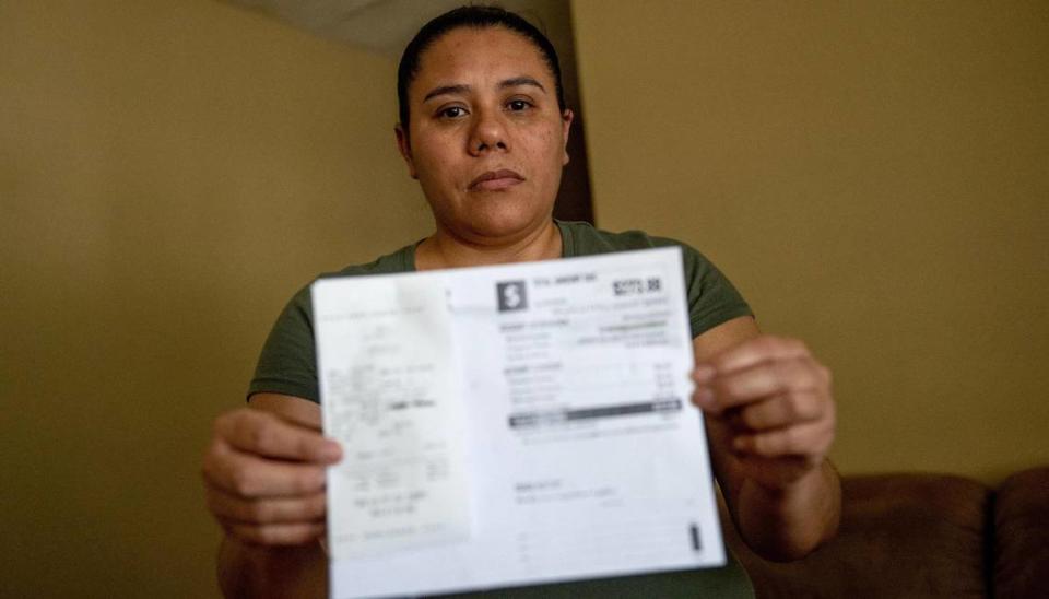 Jessica Martinez poses for a photo with a receipt showing she paid KC Water $610 on Friday, May 26, 2023, in Kansas City. Due to an outstanding balance left by a previous tenant, KC Water shut off water to Martinez’s home in April. Since then, her family has had to get creative for their water needs including transporting old pop bottles and buckets full of water by car to their home and using bottled water to brush their teeth.