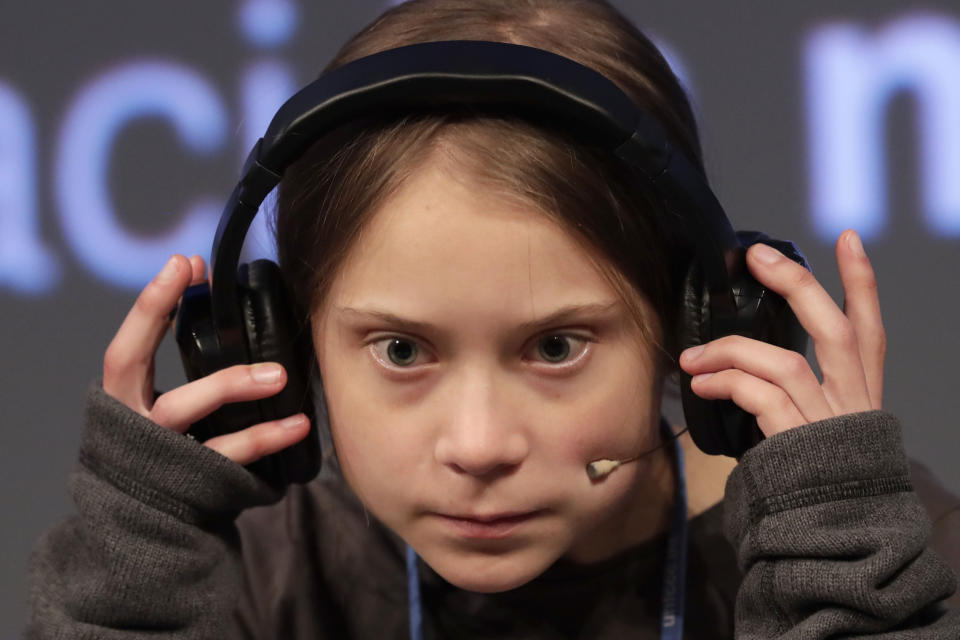 Climate activist Greta Thunberg adjusts the headphones during a press conference in Madrid, Friday Dec. 6, 2019. Thunberg arrived in Madrid Friday to join thousands of other young people in a march to demand world leaders take real action against climate change. (AP Photo/Bernat Armangue)