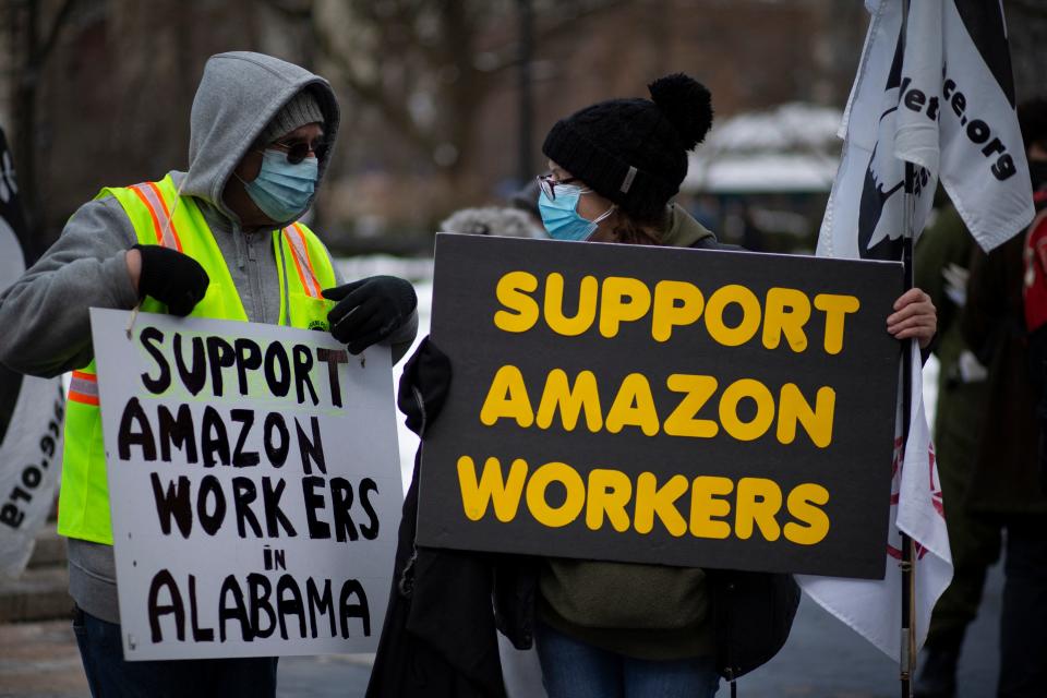 In this file photo people hold placards during a protest in support of Amazon workers in Union Square, New York on February 20, 2021. - US President Joe Biden on February 28, 2021 backed the right of Amazon workers to unionize, but stopped short of explicitly encouraging them to form a union.