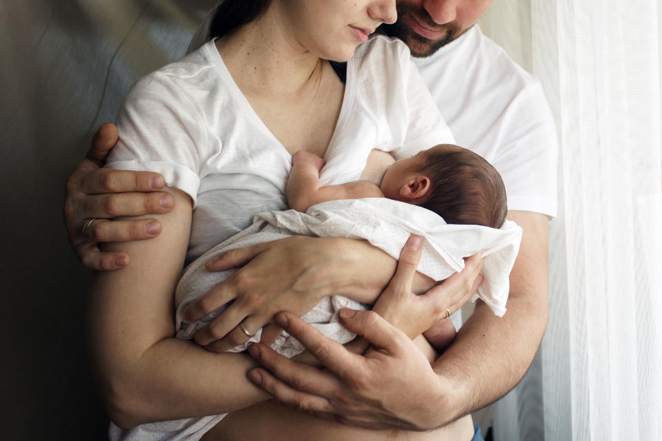 Father and mother with a newborn son. New young multi-generation family.