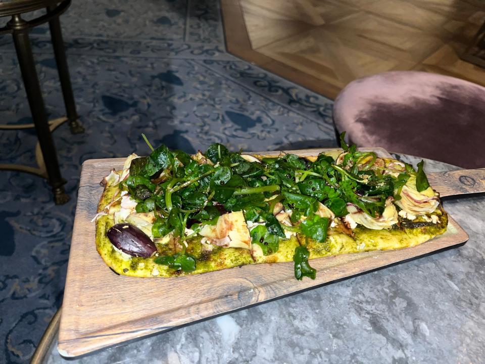 seasonal flatbread on a wooden pizza plate at enchanted rose in the grand floridian