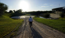 Tomas De Leon, foreman of the Hidalgo County Irrigation District #3 pump station, walks along a canal that feeds water from the Rio Grande, Tuesday, Sept. 14, 2021, in Hidalgo, Texas. Under a 1944 treaty, Mexico and the U.S. share water from the Rio Grande for use in agriculture, industries and households. Since then, the border cities of McAllen, Brownsville, Reynosa and Matamoros have ballooned — along with their water needs. (AP Photo/Eric Gay)