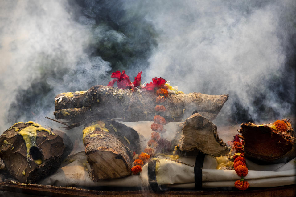 The body of a person who died of COVID-19 is cremated in Gauhati, India, Monday, May 24, 2021. India crossed another grim milestone Monday of more than 300,000 people lost to the coronavirus as a devastating surge of infections appeared to be easing in big cities but was swamping the poorer countryside. (AP Photo/Anupam Nath)