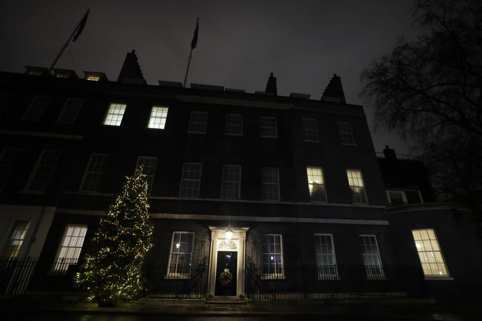 A view of the Christmas tree outside 10 Downing Street in London as people wait for news on Brexit trade talks, Wednesday, Dec. 23, 2020. European Union and British negotiators are closing in on a trade deal with only a disagreement over fishing remaining, After resolving a few remaining fair competition issues, negotiators were dealing with EU fisheries rights in U.K. waters Wednesday as they worked to secure a deal for a post-Brexit relationship after nine months of talks. (AP Photo/Kirsty Wigglesworth)