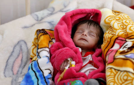 A malnourished boy lies on a bed at a malnutrition treatment center in Sanaa, Yemen November 21, 2017. REUTERS/Khaled Abdullah