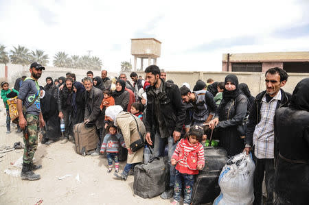 People are seen evacuated by Syrian forces from eastern Ghouta in Saqba, Syria, March 18, 2018. SANA/Handout via REUTERS