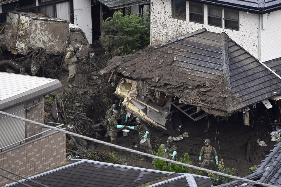 Rescuers continue a search operation for missing people at the site of a mudslide in Atami, southwest of Tokyo Wednesday, July 7, 2021. Workers are searching carefully inside homes that were destroyed and filled with mud in Saturday's disaster. (Kyodo News via AP)