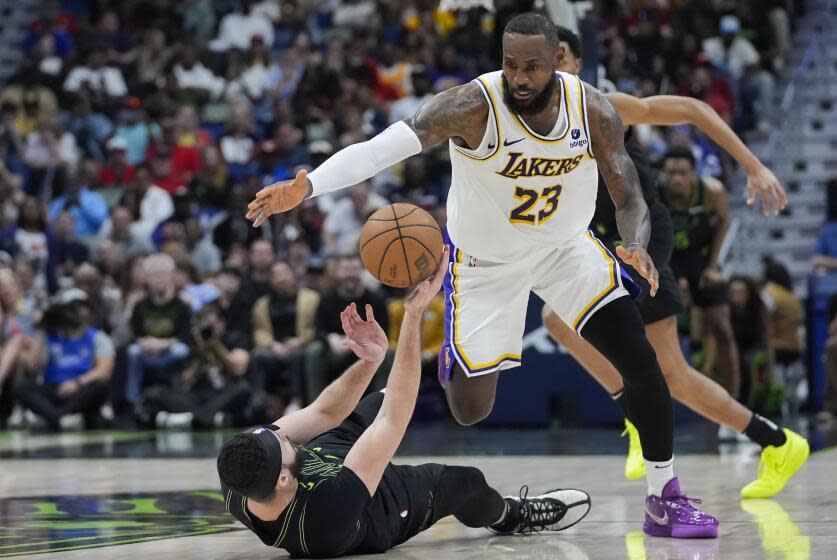 Los Angeles Lakers forward LeBron James (23) moves to steal the ball from fallen New Orleans Pelicans forward Larry Nance Jr.