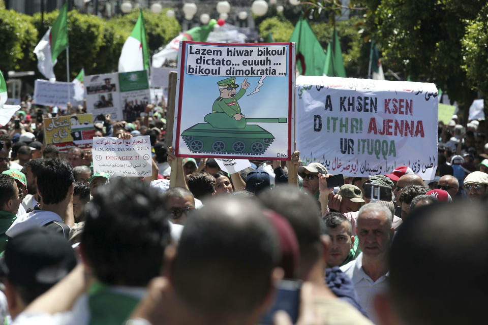Algerian protesters gather during an anti-government demonstration in the centre of the capital Algiers, Algeria, Friday, May 31, 2019. Banner in Arabic mocking army chief says "There must be a dialogue, as dictator.. democratically as possible." (AP Photo/Fateh Guidoum)