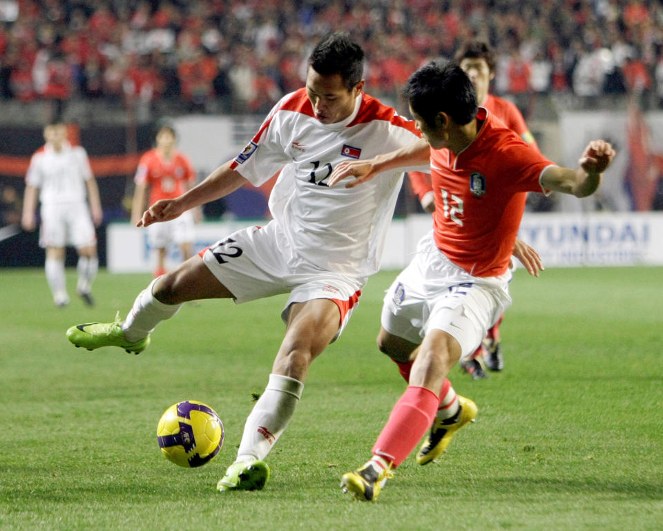 FILE - In this April 1, 2009, file photo, North Korea's Jong Tae Se, left, fights for the ball against South Korea's Lee Young-pyo during their 2010 FIFA World Cup Asia group 2 qualifying soccer match at Seoul World Cup Stadium in Seoul, South Korea. South Korean officials say North Korea has told soccer's Asian governing body it will not participate in World Cup qualifiers next month because of coronavirus concerns. Kim Min-soo, an official from the Seoul-based Korean Football Association, on Tuesday, May 4, 2021, said the Asian Football Confederation has requested North Korea to reconsider its decision. He said the North notified the AFC last week of its intent to drop out of the matches.(AP Photo/ Lee Jin-man, File)