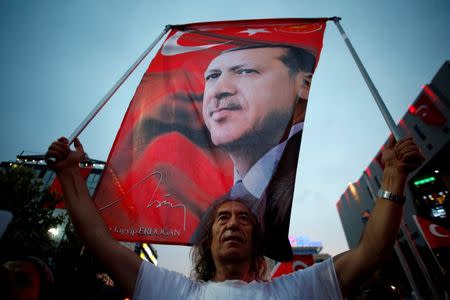 A supporter holds a flag depicting Turkish President Tayyip Erdogan during a pro-government demonstration in Ankara, Turkey, July 20, 2016. REUTERS/Baz Ratner