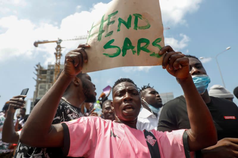 A demonstrator carries a banner during a protest over alleged police brutality, in Lagos