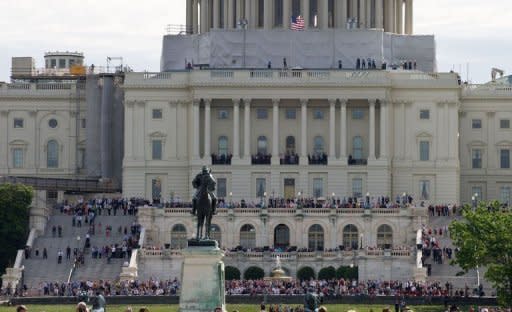 People gather at the US Capitol to watch space shuttle Discovery sitting atop a 747 as it flies over Washington en route to the National Air and Space Museum