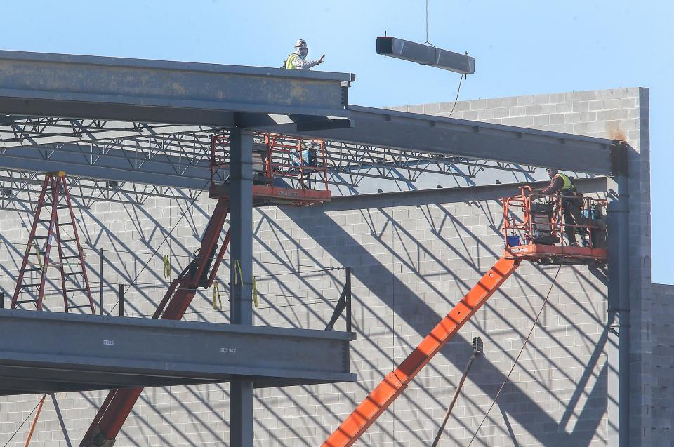 Construction workers lower a steel beam on the new Cuyahoga Falls 6-12 school on Tuesday.