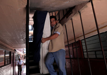 Residents remove a mattress outside their apartment where a building was damaged by the devastating earthquake, that took place in Mexico City last year in the Tlalpan neighbourhood, Mexico, August 28, 2018. Picture taken August 28, 2018. REUTERS/Henry Romero