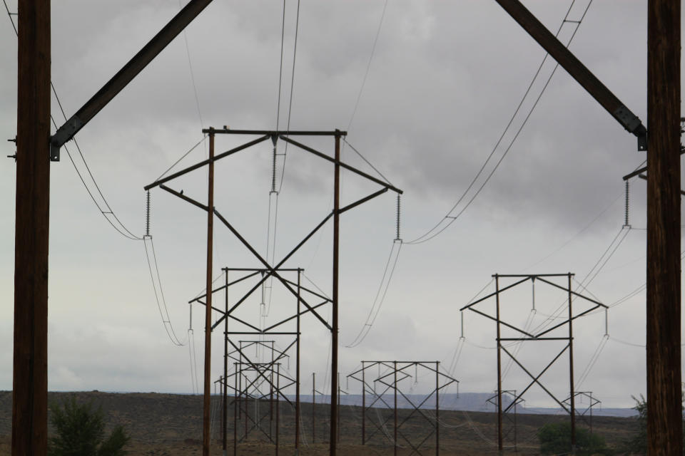 Transmission lines leading from the San Juan Generating Station near Waterflow, N.M., are seen Sept. 21, 2022. The power plant burned its last bit of coal before the end of September. Public Service Co. of New Mexico executives told state regulators during a recent meeting that they are still searching for options to replace some of the lost capacity for the 2023 peak season. (AP Photo/Susan Montoya Bryan)