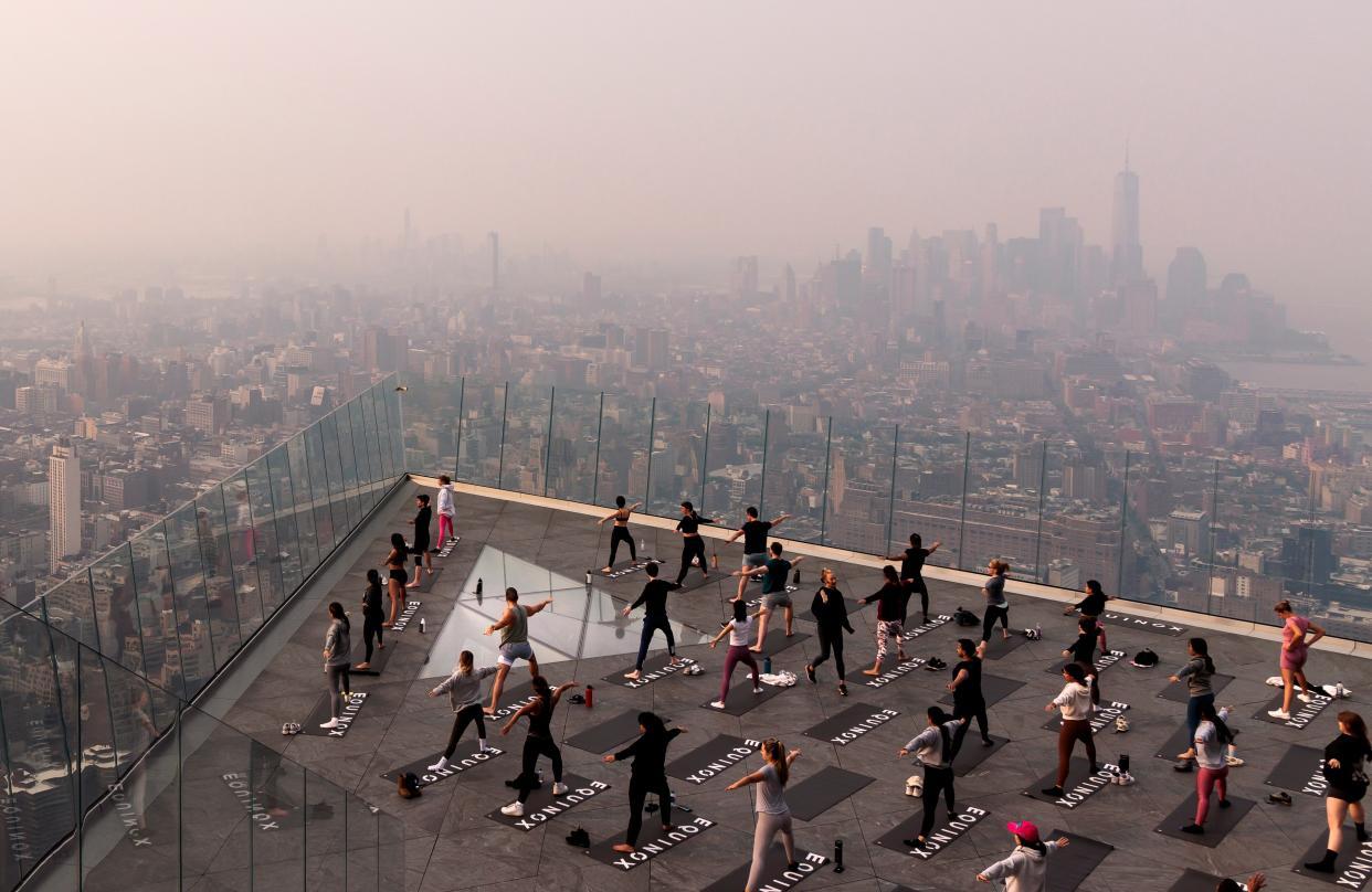People attend a morning yoga class on The Edge observation deck on the west side of Manhattan as a haze caused by smoke from wildfires burning in Canada hangs over the city (EPA)