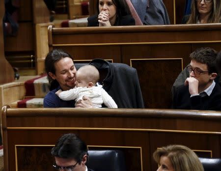 FILE PHOTO: Podemos (We Can) party leader Pablo Iglesias holds the infant son of fellow party deputy Carolina Bescansa (not pictured) as parliament convened for the first time following a general election in Madrid, Spain, January 13, 2016. REUTERS/Juan Medina/File Photo