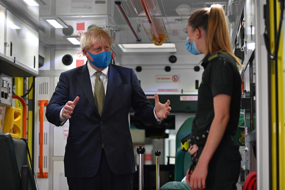 Prime Minister Boris Johnson, wearing a face mask, talks with a paramedic as they stand inside the back of an ambulance during a visit to the headquarters of the London Ambulance Service NHS Trust.