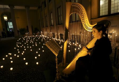 An artist plays the harp before the Roberto Cavalli Autumn/Winter 2016 woman collection during Milan Fashion Week, Italy, February 24, 2016. REUTERS/Stefano Rellandini