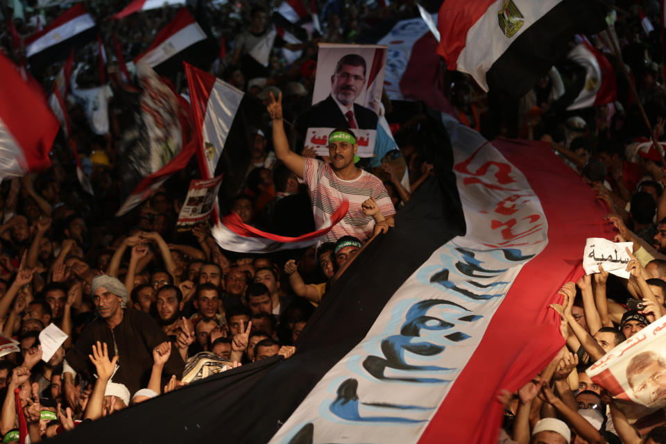 FILE - In this Friday, Aug. 2, 2013 file photo, Supporters of Egypt's ousted President Mohammed Morsi hold a large Egyptian national flag as chant slogans against Egyptian Defense Minister Gen. Abdel-Fattah el-Sissi outside Rabaah al-Adawiya mosque, where supporters of Egypt's ousted President Mohammed Morsi have installed a camp and hold daily rallies at Nasr City, in Cairo, Egypt. Egyptian officials say security authorities leaked a recording of a private conversation between ousted President Mohammed Morsi and his lawyer on the sidelines of his trial, in which Morsi says protests by his supporters and the crackdown on them are "useless."(AP Photo/Hassan Ammar, File)