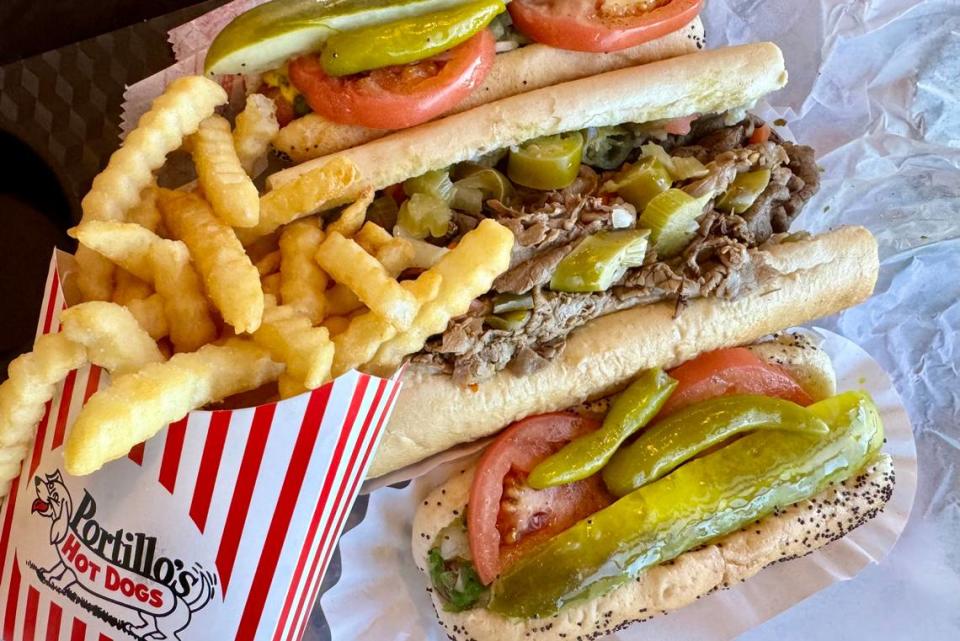 A Chicago dog (from top), Italian beef and a plant-based Chicago dog with fries at Portillo’s in Arlington.