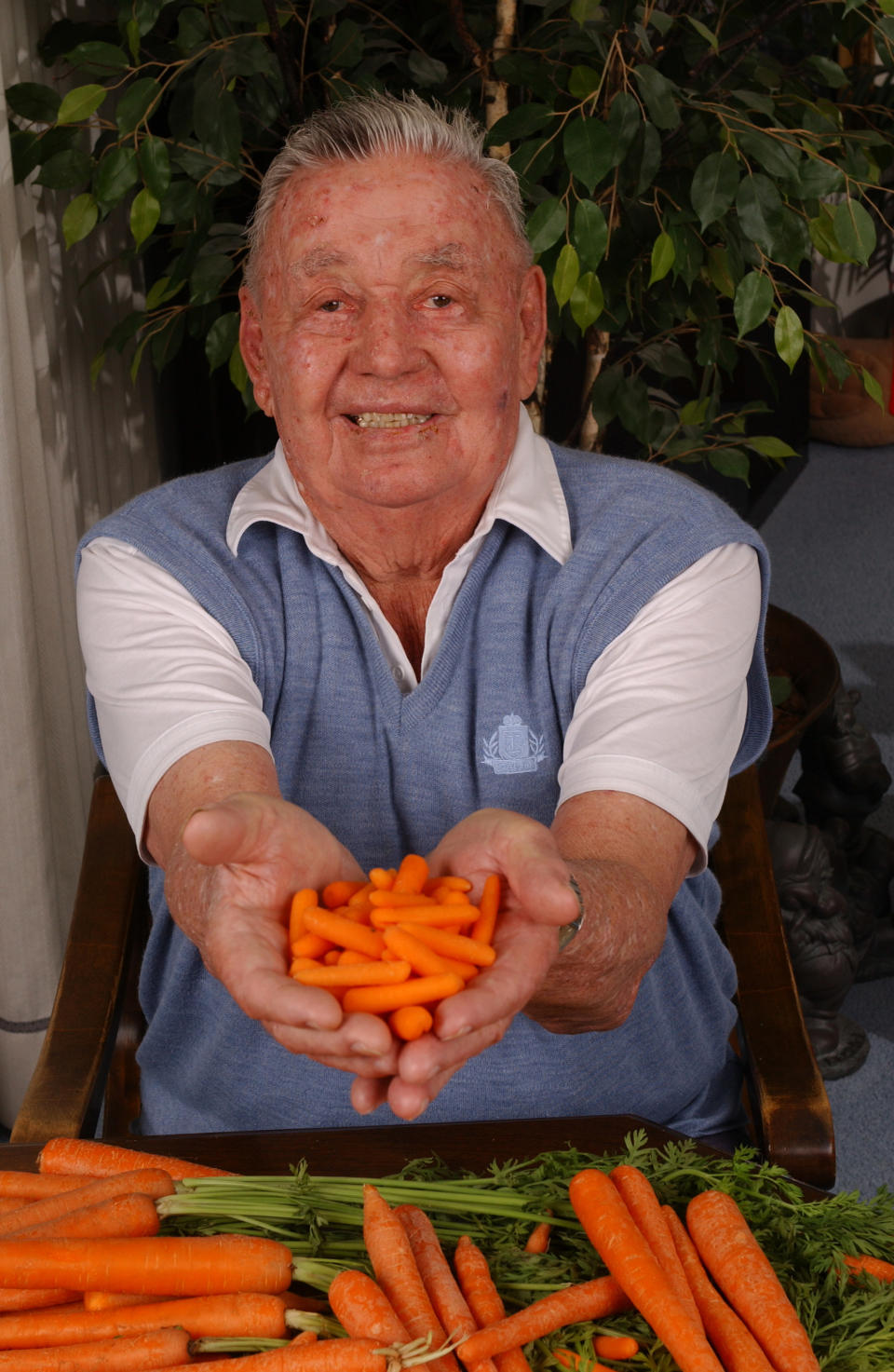 A man holding baby carrots