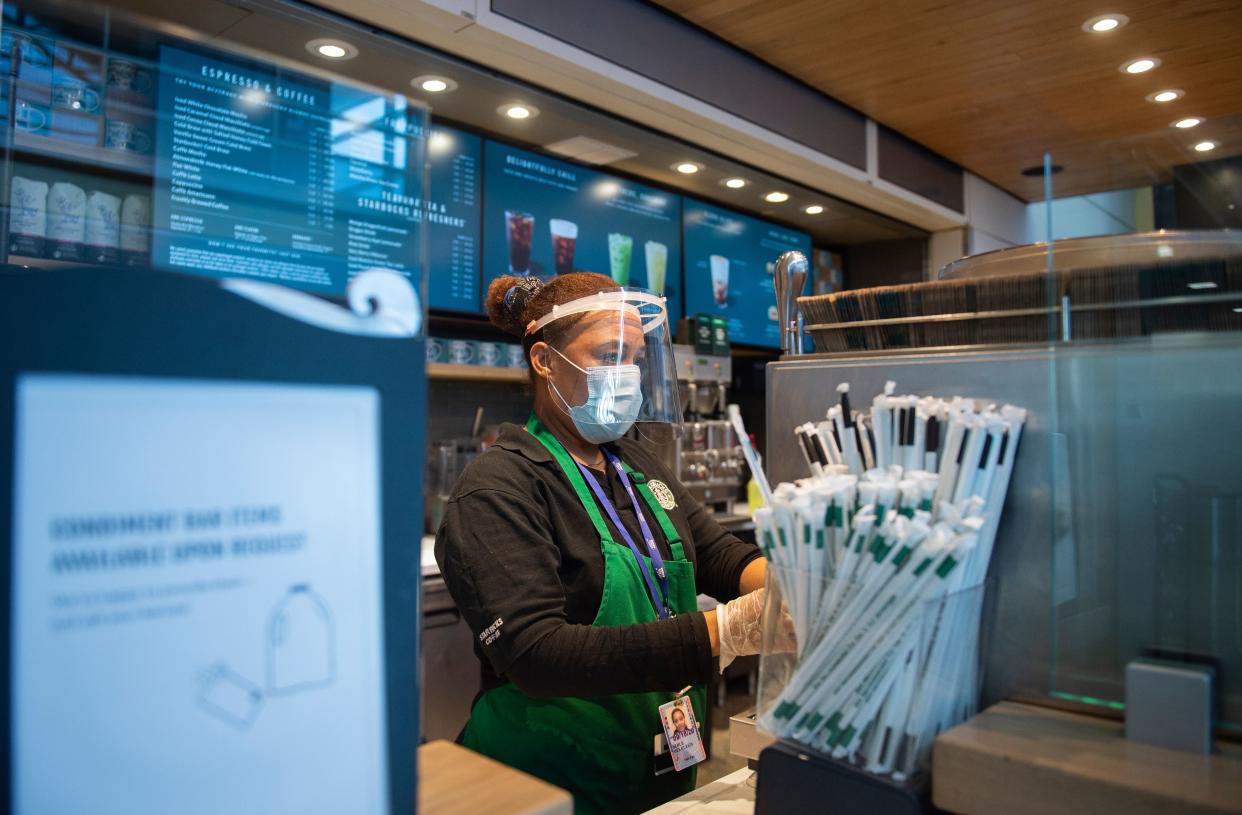 A Starbucks employee wears a face shield and mask as she makes a coffee in Ronald Reagan Washington National Airport in Arlington, Virginia, on May 12, 2020. - The airline industry has been hit hard by the COVID-19 pandemic, with the number of people flying having decreased by more than 90 percent since the beginning of March. (Photo by ANDREW CABALLERO-REYNOLDS / AFP) (Photo by ANDREW CABALLERO-REYNOLDS/AFP via Getty Images)