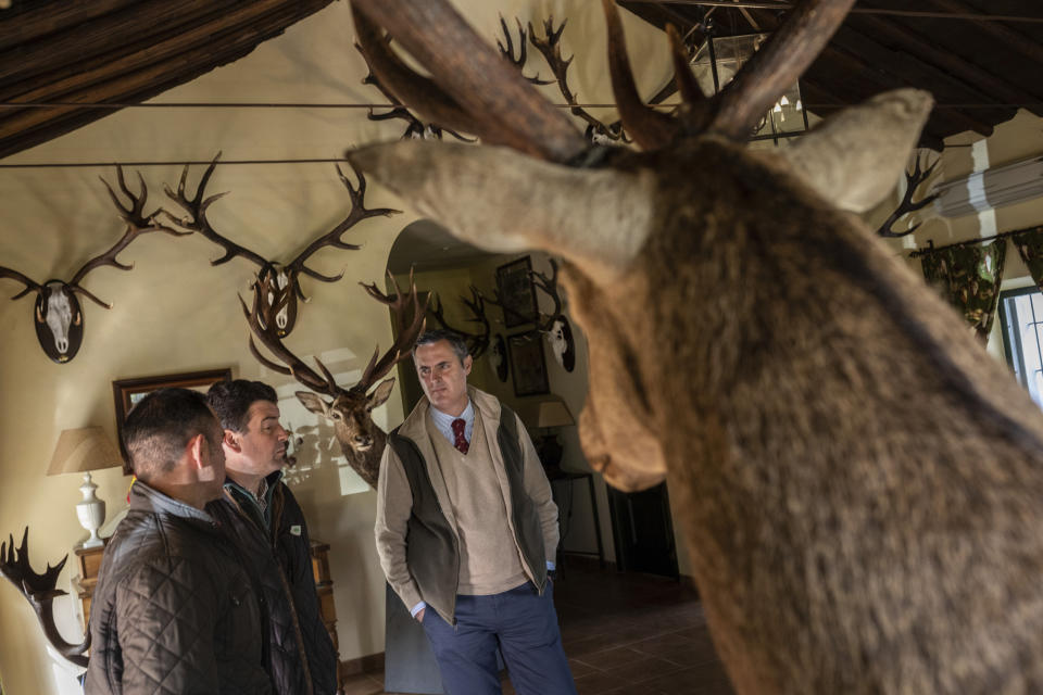 In this April 10, 2019 photo, Director of Lagunes ranch Ignacio Enrile Sanchez de Ibarguen, right, talks with Vox's Ciudad Real provincial candidate Ricardo Chamorro, center, at Lagunes ranch, central Spain. Chamorro was telling owners and staff that his upstart party will undertake an unapologetic defense of hunting against "lefties, ecologists and animalists who tell rural dwellers how to live their lives." Politicians are swapping campaign buses for tractors, buddying up with hunters and inspecting the tenderness of tomatoes in the otherwise neglected, emptying Spain as they compete for votes in Sunday's general election, perhaps the most contested and polarized in the country's recent history. (AP Photo/Bernat Armangue)