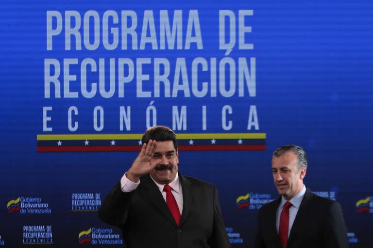 This handout picture released by the Venezuelan Presidency shows President Nicolas Maduro (L) gesturing next to Minister of Industries and National Production Tareck El Aissami, during a meeting with Venezuelan businessmen at the Miraflores presidential palace in Caracas on September 5, 2018. (Photo