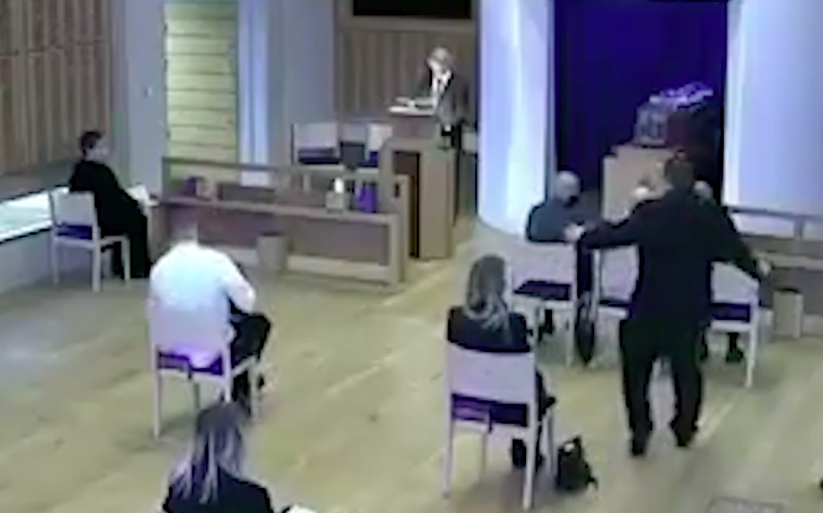 A staff member, standing, tells mourners not to sit together. (Milton Keynes Community Hub)