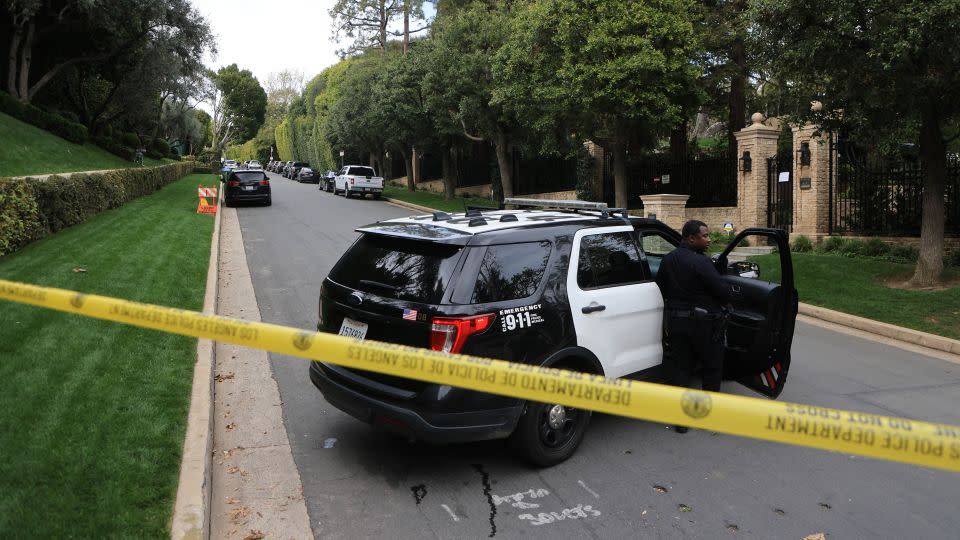 Police cars are seen behind caution tape outside the home of US producer and musician Sean "Diddy" Combs in Los Angeles on March 25, 2024. - David Swanson/AFP/Getty Images