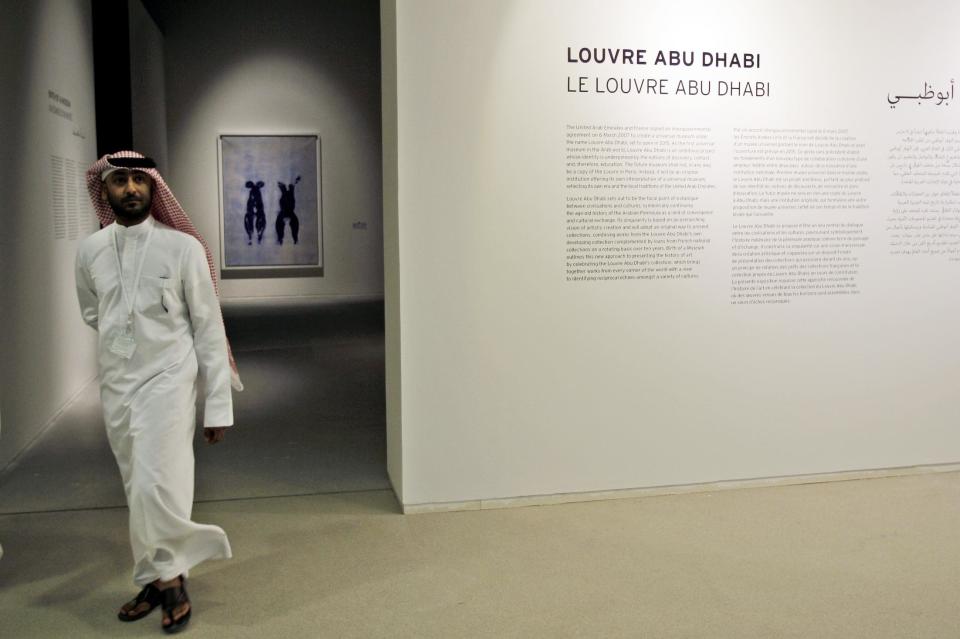 An Emirati visitor passes in front of "Anthropometry" by French artist Yves Klein which is part of a sample collection at the Abu Dhabi branch of the Louvre in Abu Dhabi, United Arab Emirates, Tuesday, April 16, 2013. No artistic subjects will be off limits at the Abu Dhabi branch of the Louvre museum as it builds its collection for a planned 2015 opening, a top overseer said Tuesday, in a city seeking to broaden its international profile but testing how far to open its conservative culture. (AP Photo/Kamran Jebreili)