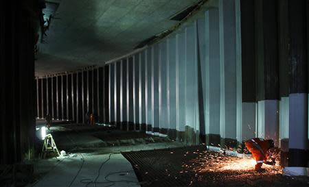 A worker works on areas of infrastructure near the construction site of the Arena das Dunas stadium, in Natal May 10, 2014. REUTERS/Nuno Guimaraes