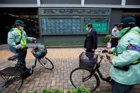 People pass in front of a stock quotation board after the Tokyo Stock Exchange (TSE) temporarily suspended all trading due to system problems in Tokyo