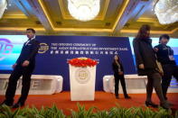 Workers walk across the stage before the opening ceremony of the Asian Infrastructure Investment Bank (AIIB) in Beijing, China, January 16, 2016. REUTERS/Mark Schiefelbein/Pool