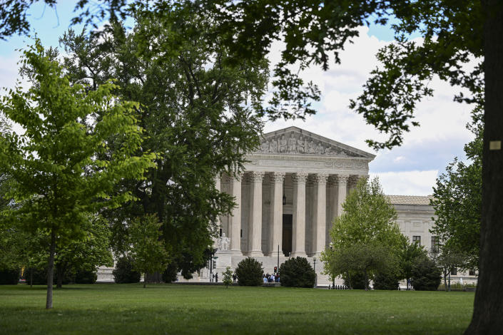 The facade of the Supreme Court framed by trees.