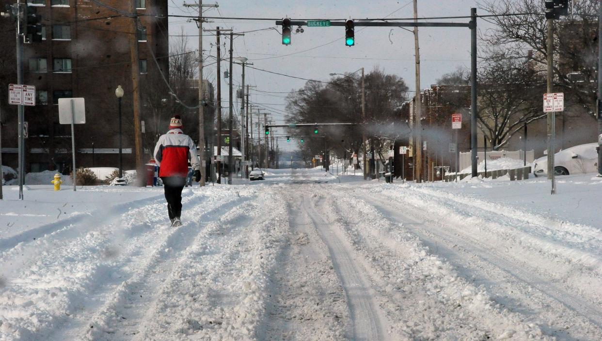 A walker treks along South Street in Wooster on Monday morning. The area received between 4 and 14 inches of snow Sunday night and Monday morning.