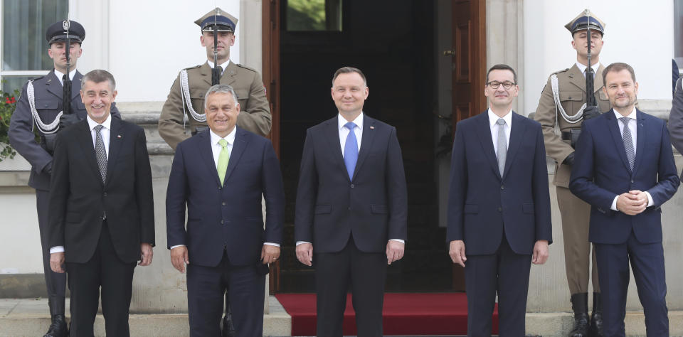 Poland's President Andrzej Duda, center, and Prime Minister Mateusz Morawiecki, second right, are taking a family photo with Slovak Prime Minister Igor Matovic, right, Czech Prime Minister Andrej Babis, left and Hungarian Prime Minister Viktor Orban, second left, at the start of a Visegrad Group summit in Warsaw, Poland, Friday, July 3, 2020, as Poland takes the rotating presidency of the regional cooperation group.(AP Photo/Czarek Sokolowski)