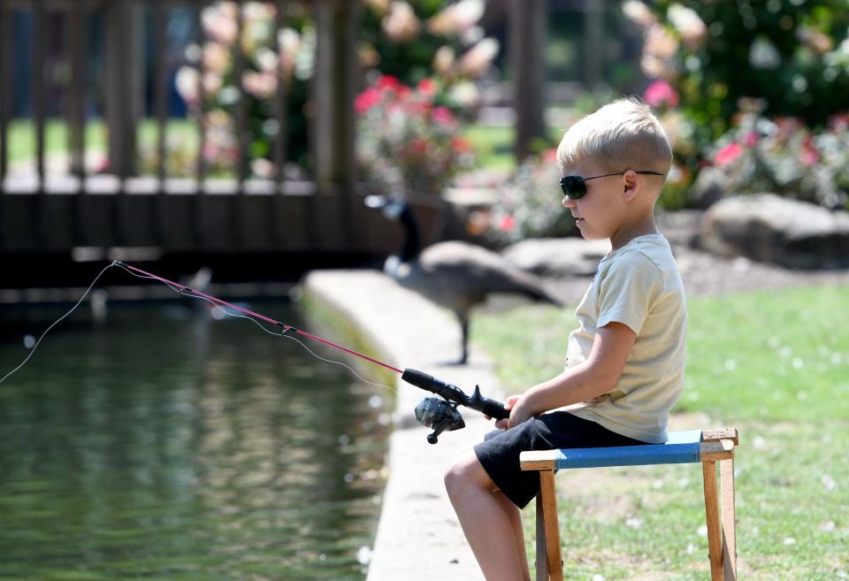 Cullen Allen, 5, of Jackson Township chills out by the side of the pond fishing at Price Park in North Canton.