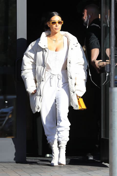 <p>In monochromatic white sweatpants, corset and oversized puffer, paired with Yeezy boots and Escada sunglasses while leaving lunch in Los Angeles. </p>