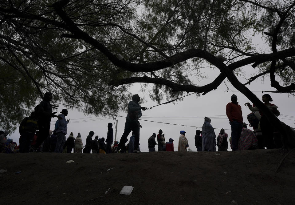 Haitian migrants hoping to apply for asylum in the U.S., gather along the U.S. Mexico border, as they wait to register with a religious organization, in Reynosa, Mexico, Wednesday, Dec. 21, 2022. (AP Photo/Fernando Llano)